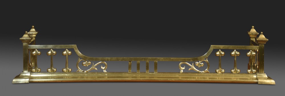 An antique solid brass Art Nouveau fireplace fender featuring stylized balusters, organic scrollwork motifs, and raised corner posts. View II