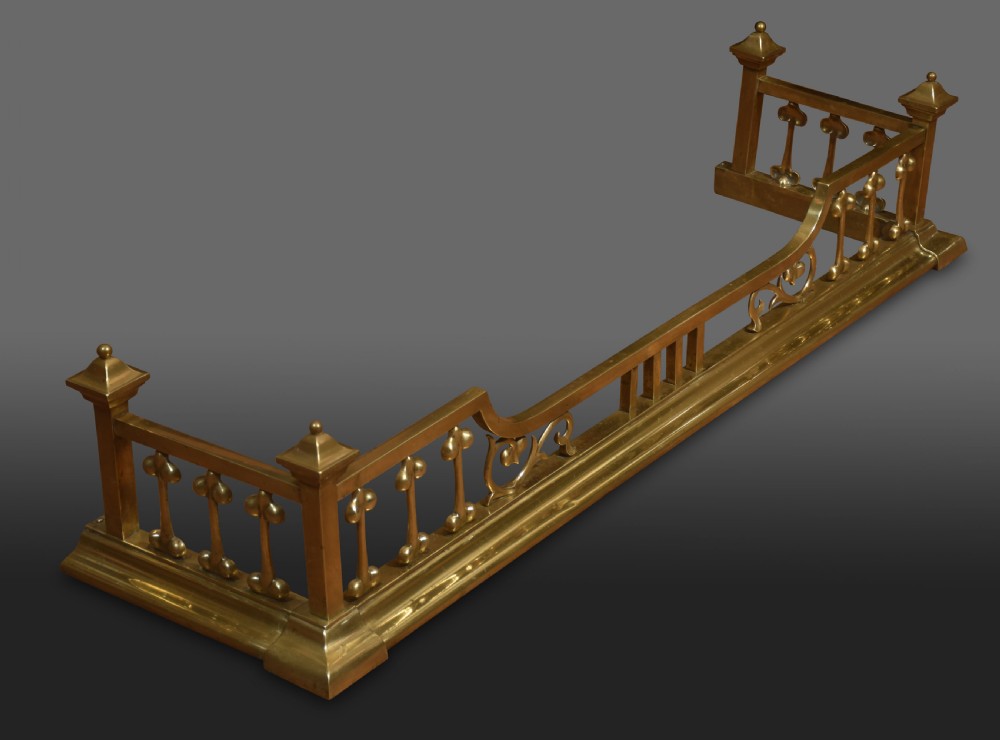 An antique solid brass Art Nouveau fireplace fender featuring stylized balusters, organic scrollwork motifs, and raised corner posts. View IV