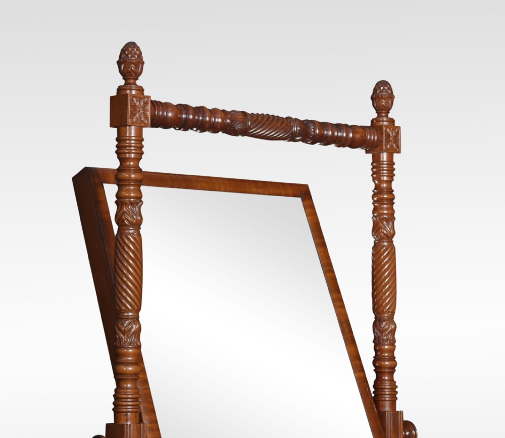 A Regency period mahogany cheval mirror featuring spiral-turned upright columns, finials, and a rectangular tilting frame resting on splayed legs with brass lion paw castors. View X