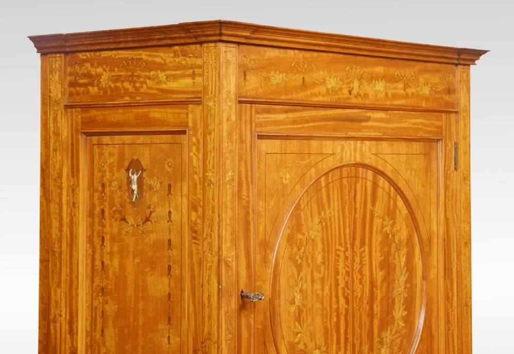 A late 19th-century satinwood side cabinet featuring intricate floral marquetry inlay, a central circular wreath medallion on a single panelled door, and square tapered legs. View V