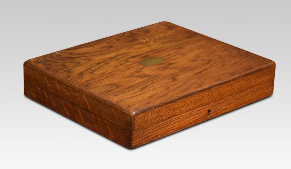 An open wooden oak case displaying a structured set of silver-plated knives and forks with mother-of-pearl handles set against dark velvet lining. View III