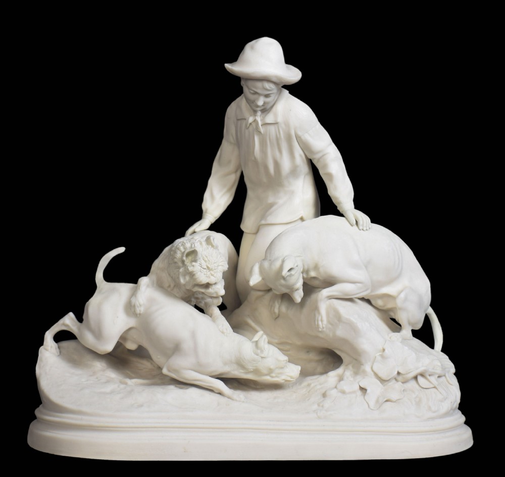 A white unglazed Victorian Parian ware sculpture depicting a young male figure leaning over three hounds on a moulded terrain base.