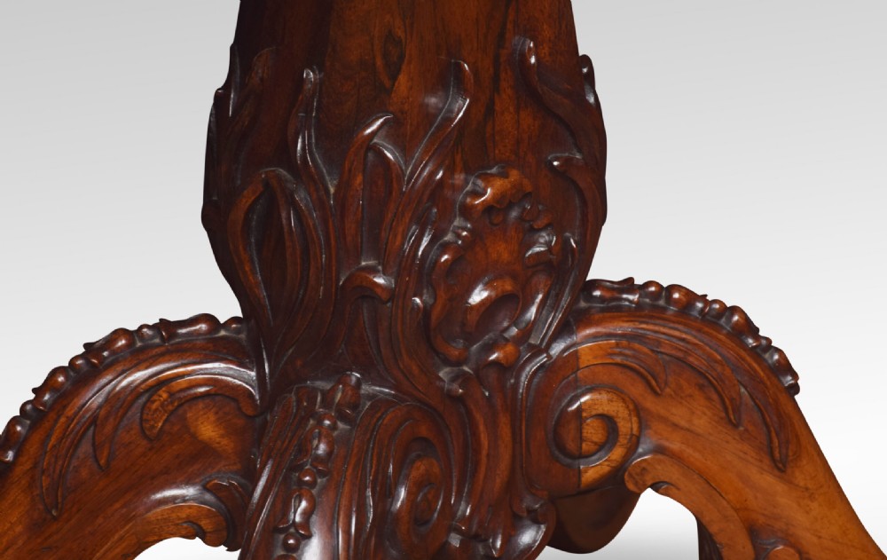 A Victorian dark rosewood fold-over card table featuring an ornate carved frieze, a central carved pedestal column, and carved scroll legs. View VI