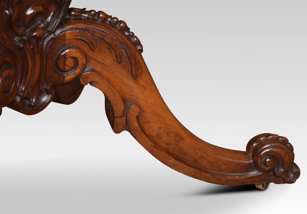 A Victorian dark rosewood fold-over card table featuring an ornate carved frieze, a central carved pedestal column, and carved scroll legs. View VII