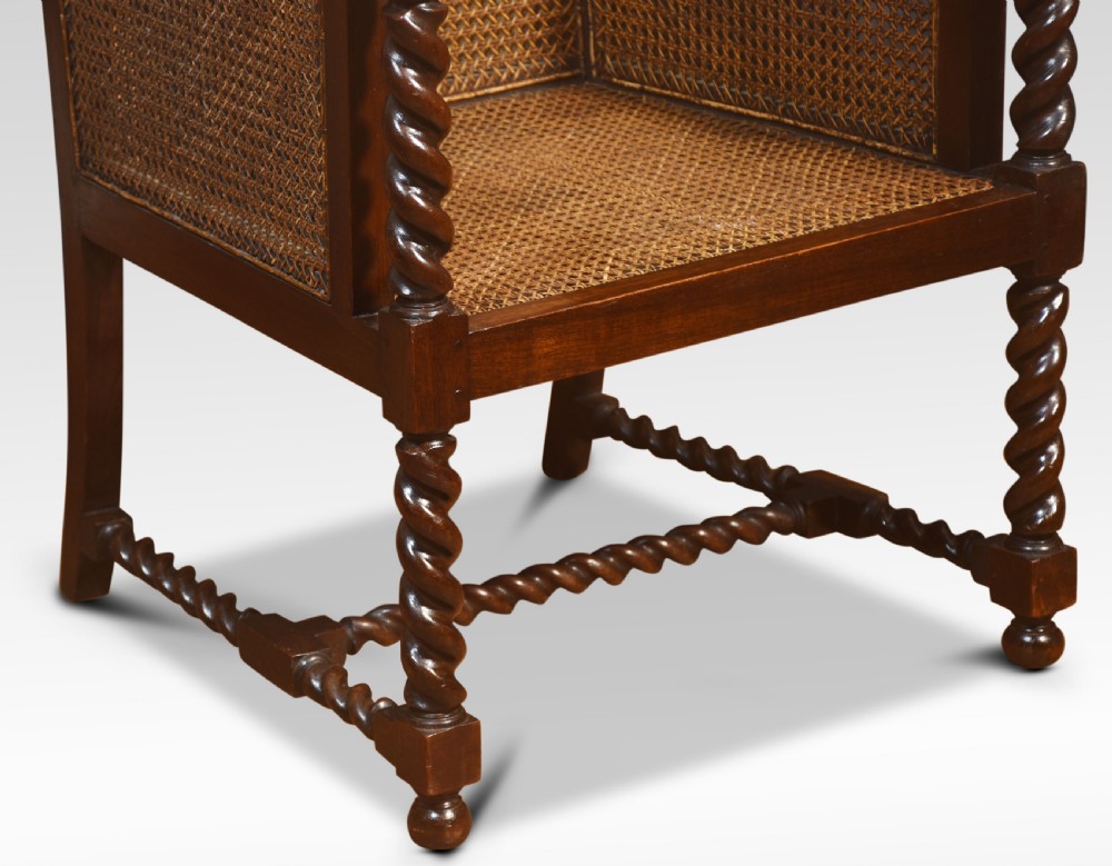 A pair of dark oak bergere library armchairs featuring barley twist legs, woven cane side panels, and deep-tufted dark green leather cushions. View VII