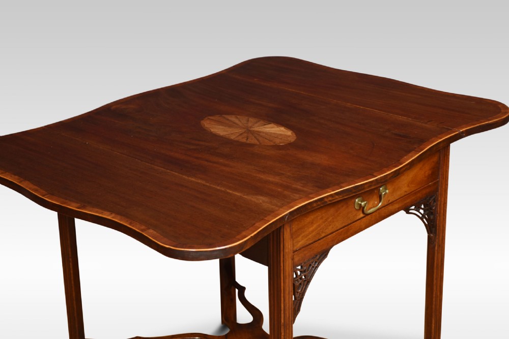 A George III mahogany Pembroke table with drop leaves, an oval satinwood inlay on top, a single drawer with a brass handle, and an X-shaped stretcher base. View III
