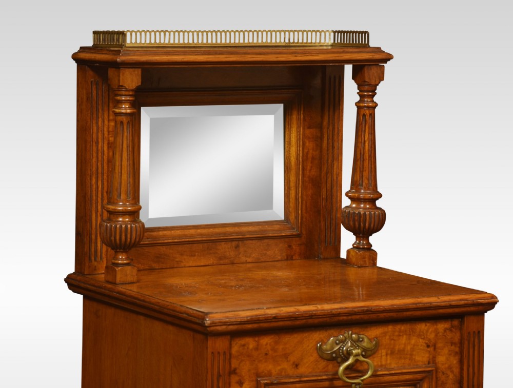 A Victorian pollard oak fireside purdonium featuring a carved floral panel, brass drop handle, turned columns, and a mirrored upper shelf with a brass gallery rail. View III