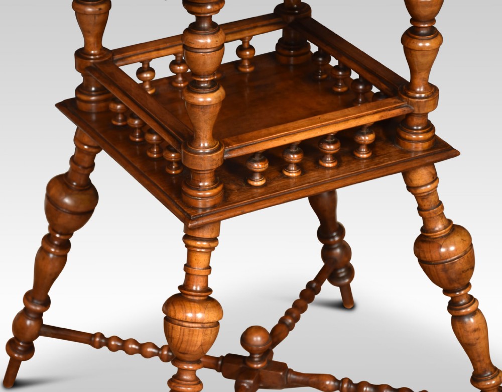 A late nineteenth-century walnut two-tier occasional table featuring turned legs, a spindle gallery on the lower shelf, and a moulded square top. View II