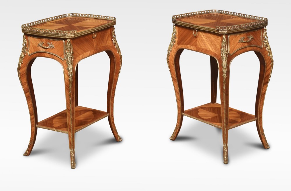 A pair of French Louis XV style walnut bedside tables featuring slender cabriole legs, brass mounts, single drawer handles, lower shelves, and pierced brass galleries around the tops. View V
