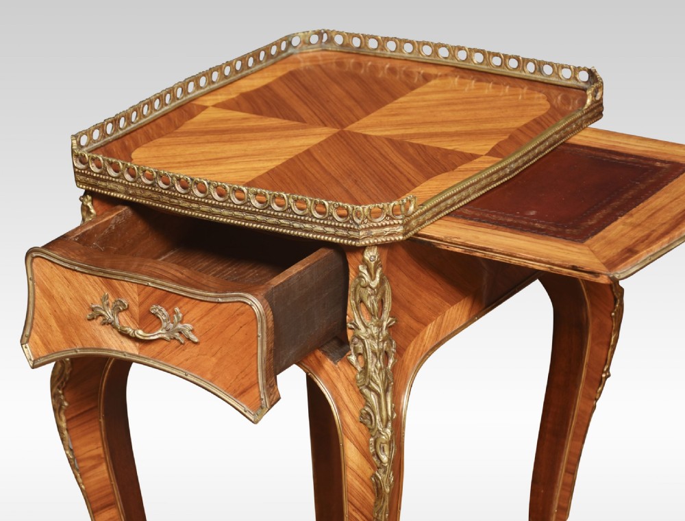 A pair of French Louis XV style walnut bedside tables featuring slender cabriole legs, brass mounts, single drawer handles, lower shelves, and pierced brass galleries around the tops. View VI