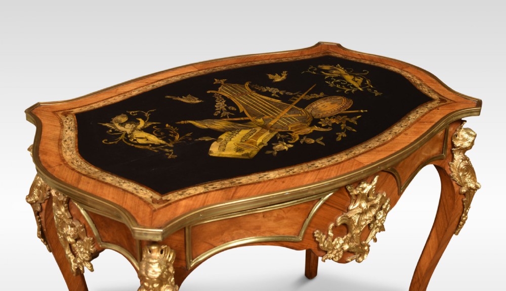 A French Louis XV style walnut centre table featuring cabriole legs, ornate gilt bronze mounts, and an ebonised top decorated with musical instrument marquetry. View IX