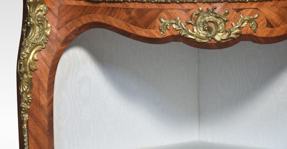 A French Louis XV style kingwood open corner cabinet featuring gilt bronze ormolu mounts, serpentine edges, and three cream fabric-lined shelves. View VIII