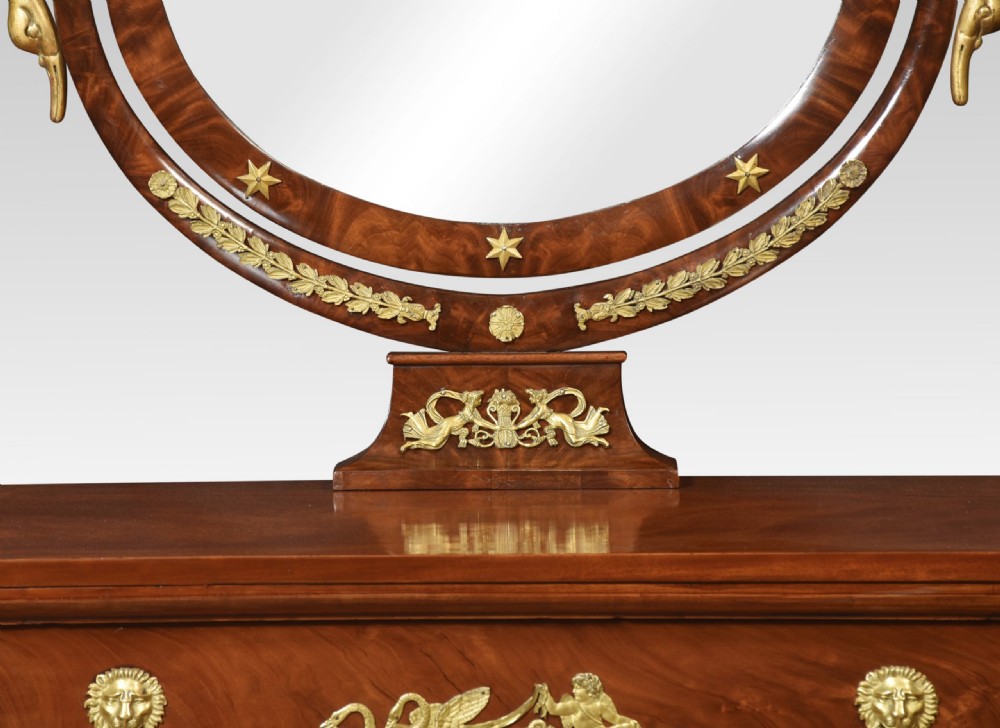 A 19th-century French Empire mahogany dressing table with an oval swivelling mirror, gilded bronze ormolu mounts, swan neck supports, and lion head handles. View IX