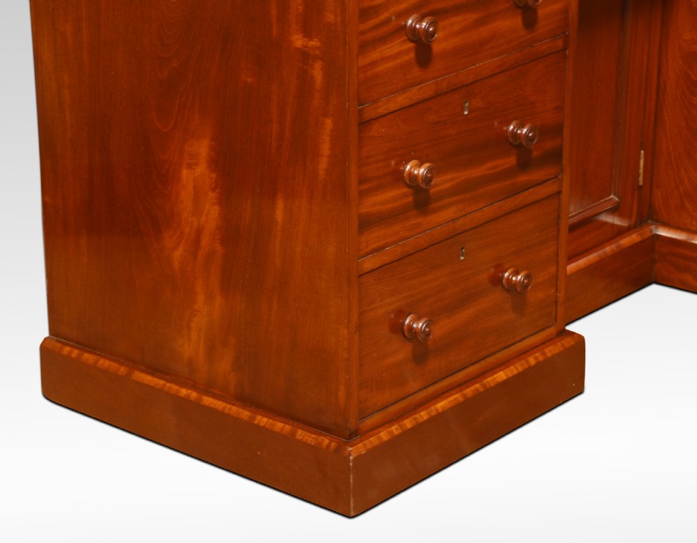 A nineteenth-century mahogany kneehole dressing table featuring an arched gallery upstand, nine drawers with turned handles, and a central cupboard door. View VI