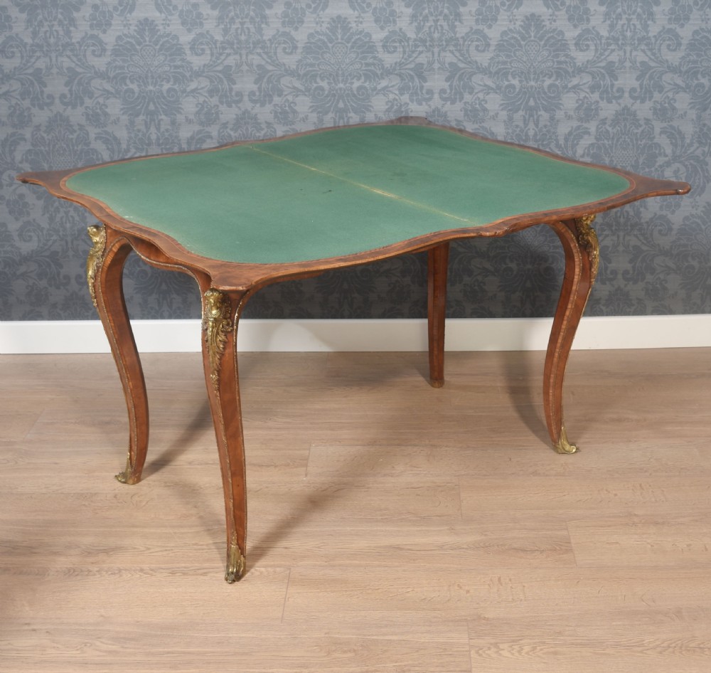 A nineteenth-century burr walnut card table featuring a serpentine top, carved frieze, cabriole legs, and ornate gilt bronze ormolu mounts. View III