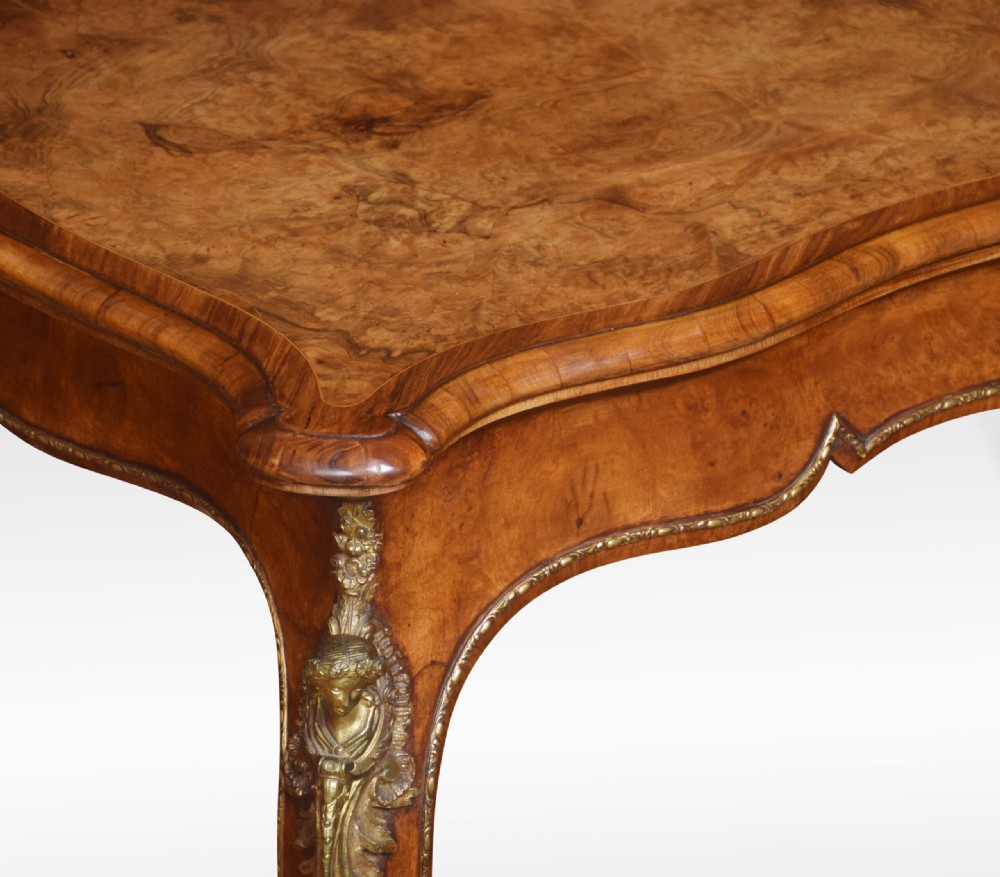 A nineteenth-century burr walnut card table featuring a serpentine top, carved frieze, cabriole legs, and ornate gilt bronze ormolu mounts. View VI