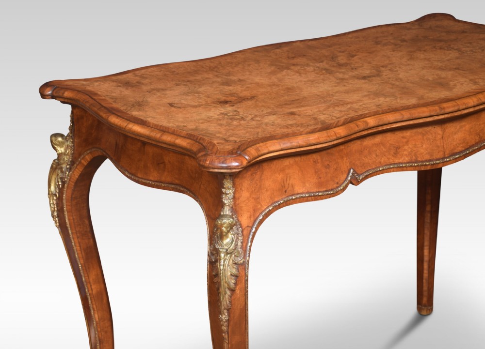 A nineteenth-century burr walnut card table featuring a serpentine top, carved frieze, cabriole legs, and ornate gilt bronze ormolu mounts. View IX