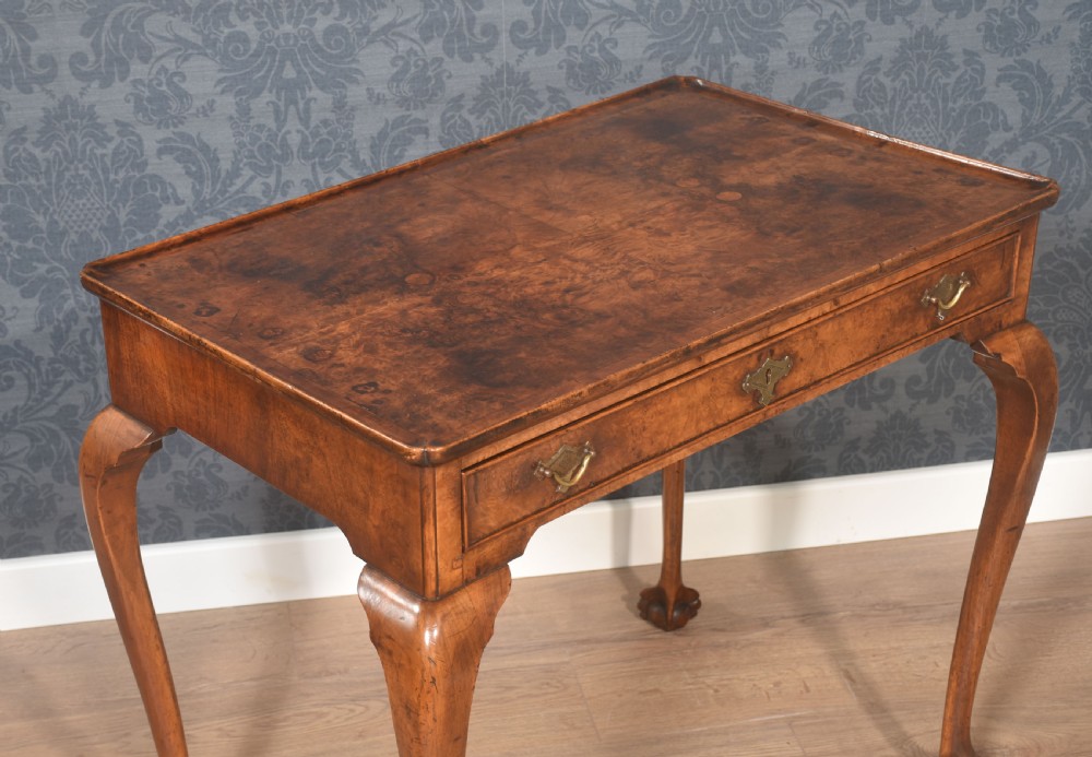 A figured walnut silver table featuring a raised tray top edge, a single frieze drawer with brass handles, and cabriole legs with claw-and-ball feet. View III