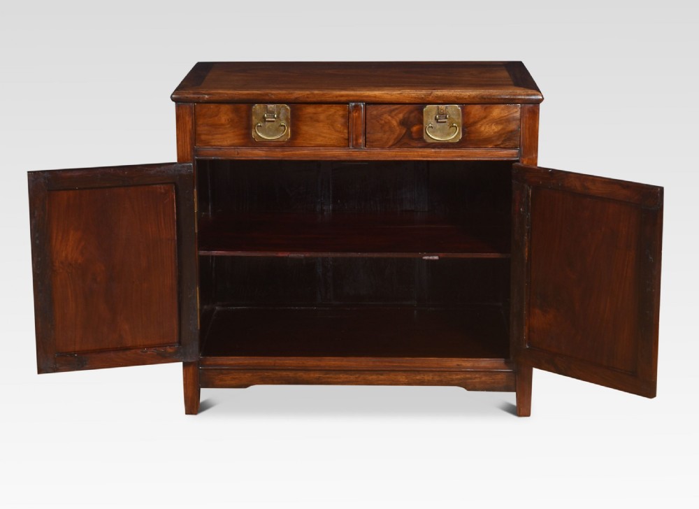 A warm brown carved Chinese wooden cupboard featuring two top drawers, brass hardware, and panelled doors depicting bird motifs. View VII