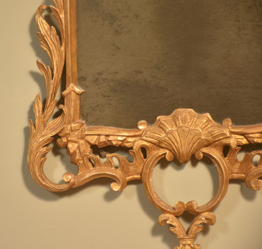 A tall rectangular Chippendale style wall mirror featuring an intricate carved giltwood frame with cresting scrollwork and shell motifs. View III