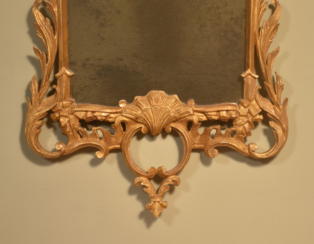 A tall rectangular Chippendale style wall mirror featuring an intricate carved giltwood frame with cresting scrollwork and shell motifs. View V