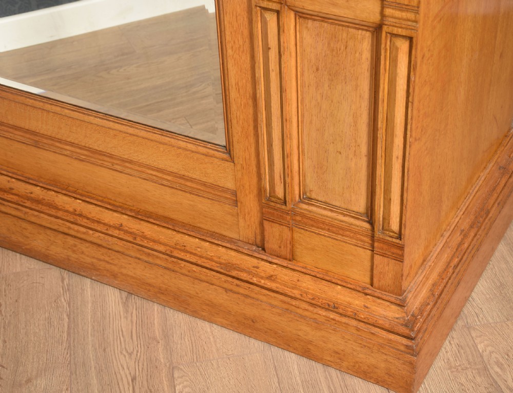 A Victorian golden oak wardrobe featuring a central mirrored door flanked by recessed panels with elaborate marquetry inlay and fluted pilasters. View IX