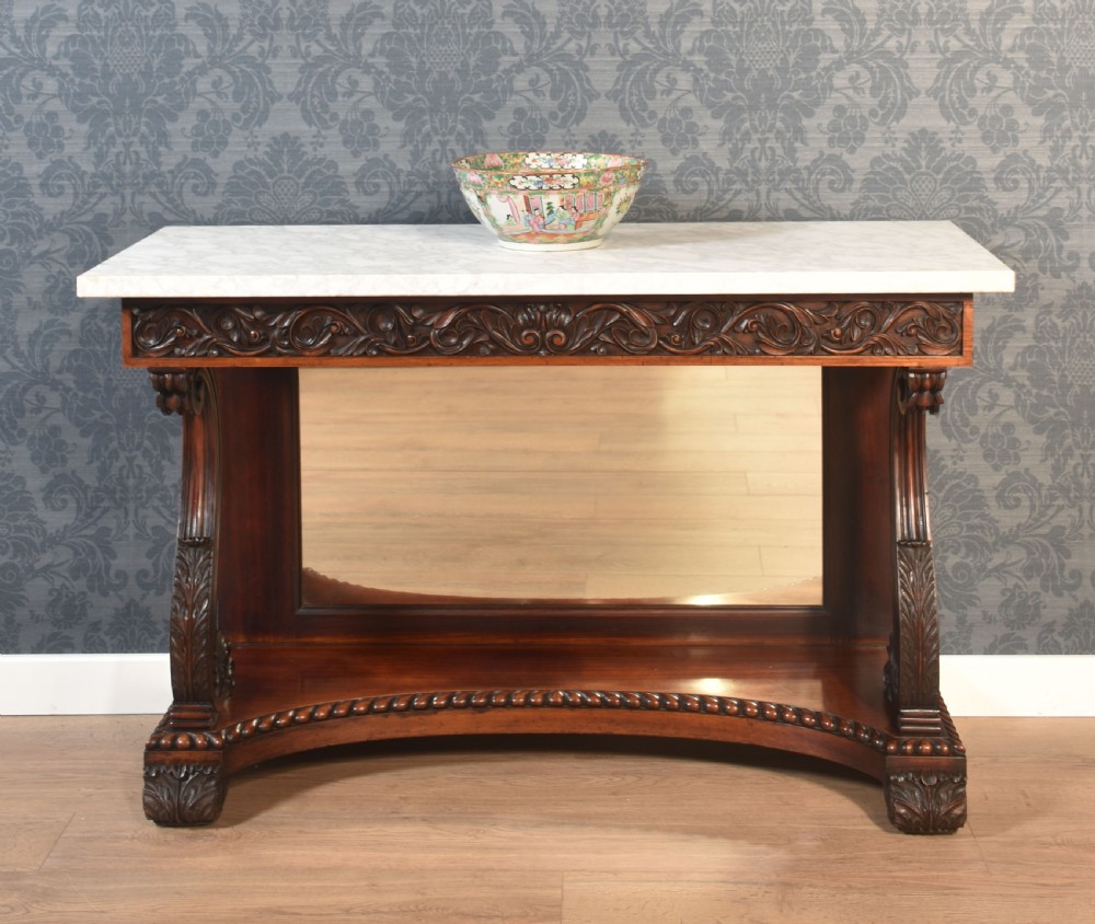 A 19th-century mahogany console table with a rectangular white marble top, carved frieze, S-shaped scroll supports, and an inset mirror back above a shaped plinth base. View II