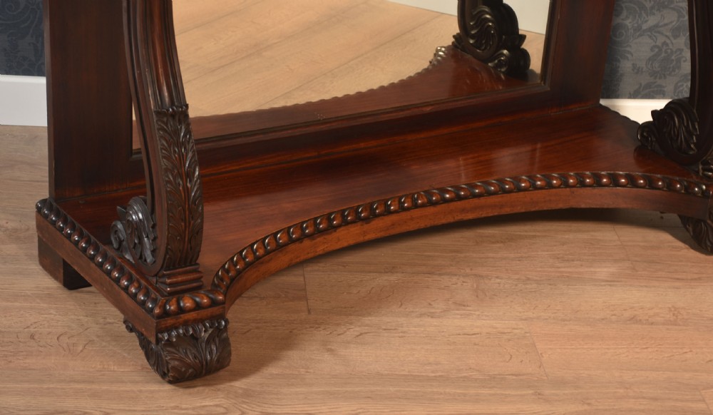 A 19th-century mahogany console table with a rectangular white marble top, carved frieze, S-shaped scroll supports, and an inset mirror back above a shaped plinth base. View VIII