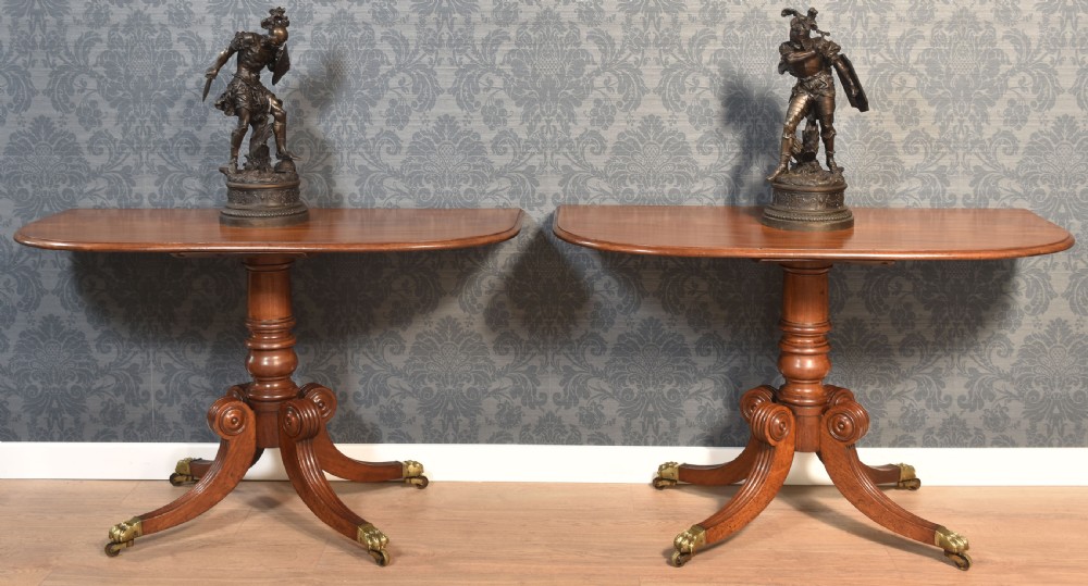 A pair of Regency mahogany semi-oval hall tables on reeded pedestal legs with brass claw feet. View II