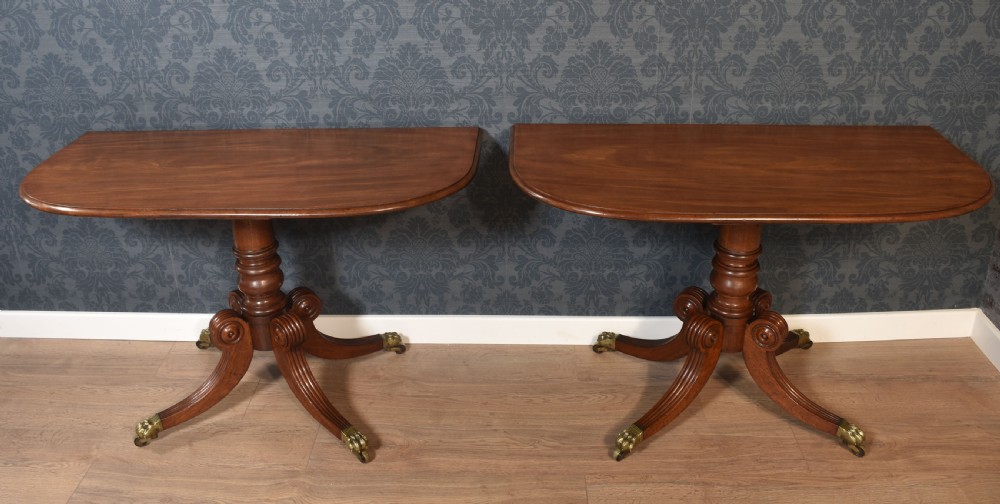 A pair of Regency mahogany semi-oval hall tables on reeded pedestal legs with brass claw feet. View V