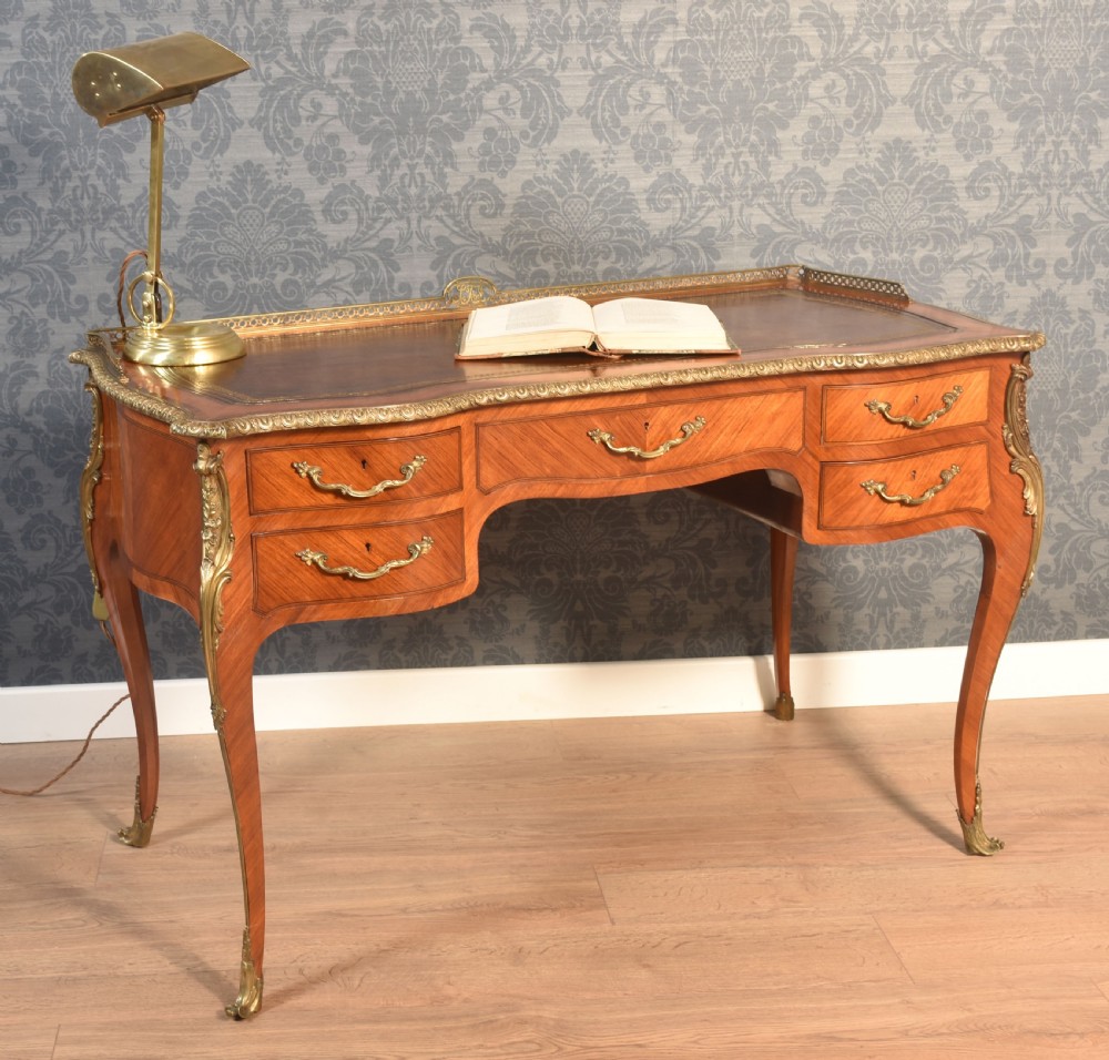 A 19th-century kingwood writing table featuring five drawers, ornate ormolu mounts, cabriole legs, and a leather-inset writing surface. View II