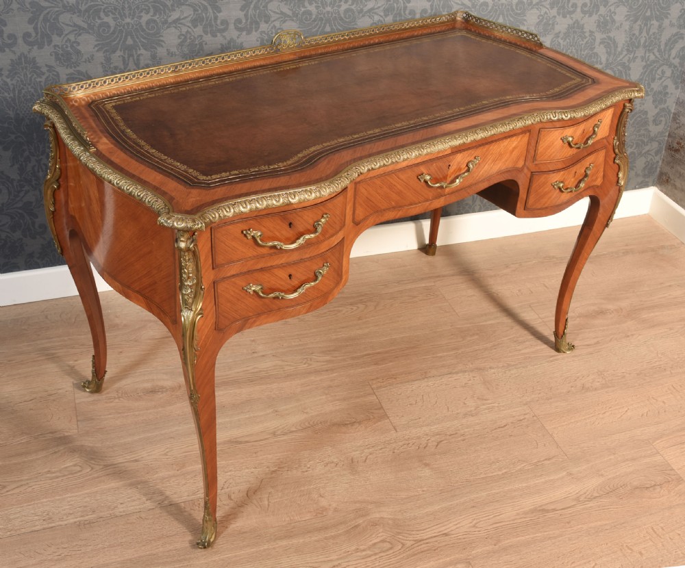 A 19th-century kingwood writing table featuring five drawers, ornate ormolu mounts, cabriole legs, and a leather-inset writing surface. View VII