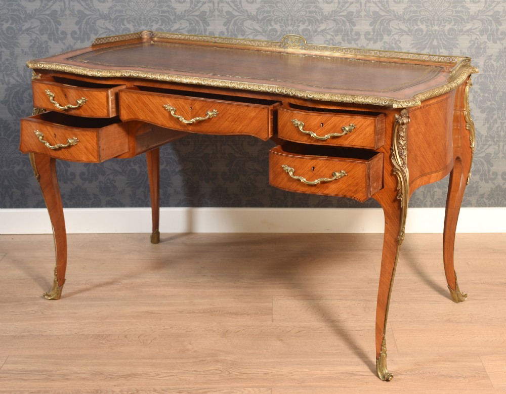 A 19th-century kingwood writing table featuring five drawers, ornate ormolu mounts, cabriole legs, and a leather-inset writing surface. View XI