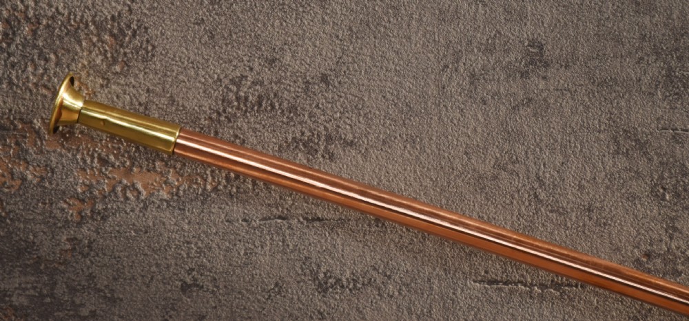 A set of two straight copper coaching horns with brass mouthpieces and flared bells, each rigged with a suspension rope. View VI
