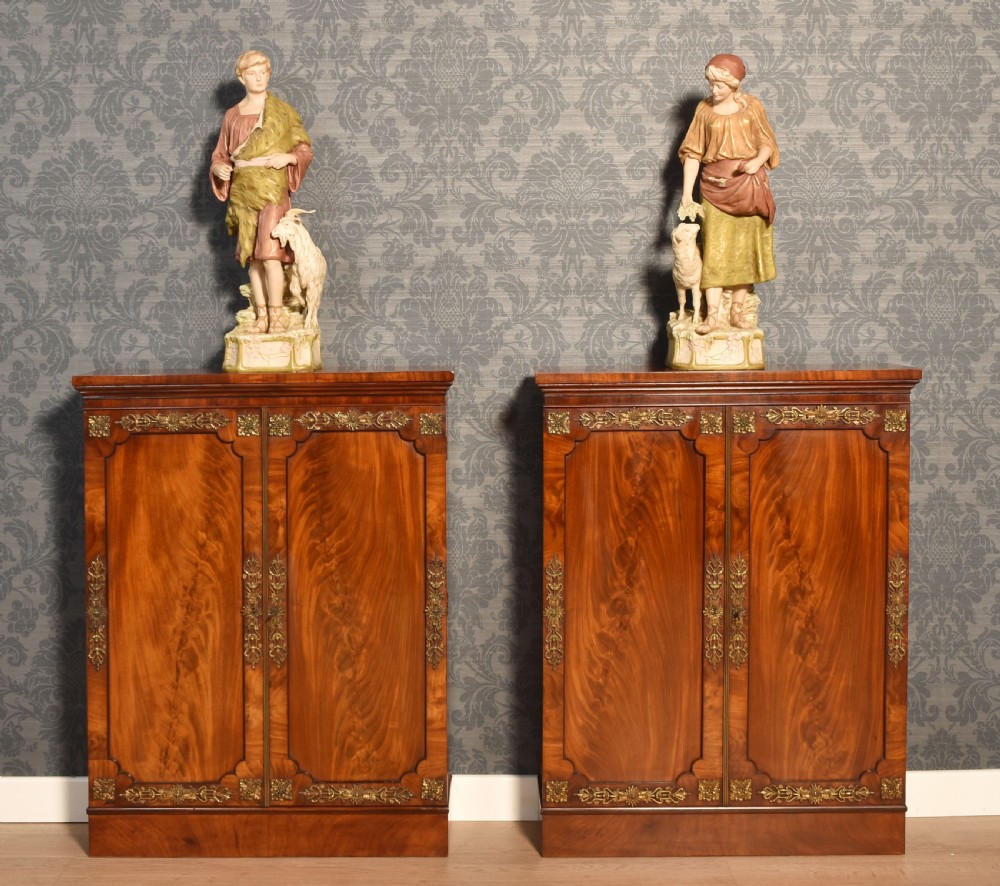 A matching pair of low mahogany side cabinets featuring double panel doors with figured flame grain and decorative gilt metal mounts. View II