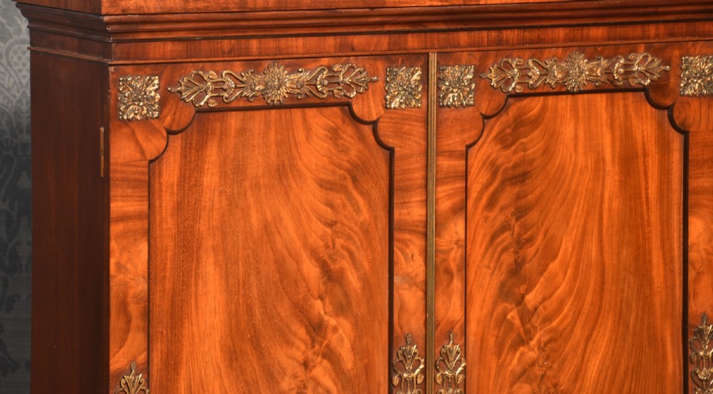 A matching pair of low mahogany side cabinets featuring double panel doors with figured flame grain and decorative gilt metal mounts. View III
