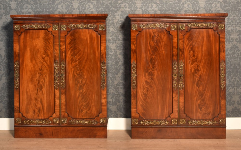 A matching pair of low mahogany side cabinets featuring double panel doors with figured flame grain and decorative gilt metal mounts. View VII