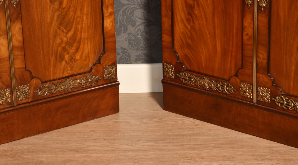 A matching pair of low mahogany side cabinets featuring double panel doors with figured flame grain and decorative gilt metal mounts. View IX