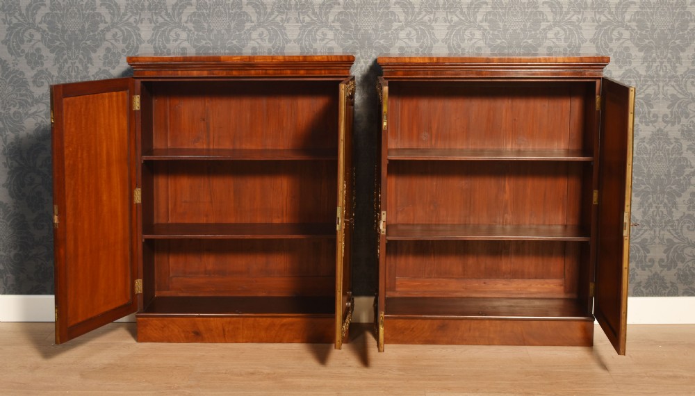 A matching pair of low mahogany side cabinets featuring double panel doors with figured flame grain and decorative gilt metal mounts. View X