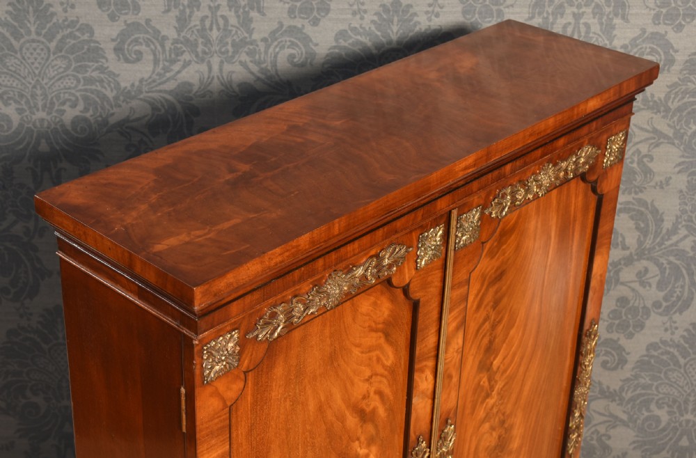 A matching pair of low mahogany side cabinets featuring double panel doors with figured flame grain and decorative gilt metal mounts. View XI