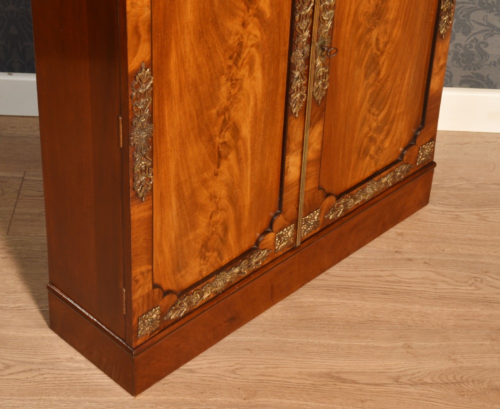 A matching pair of low mahogany side cabinets featuring double panel doors with figured flame grain and decorative gilt metal mounts. View XIII