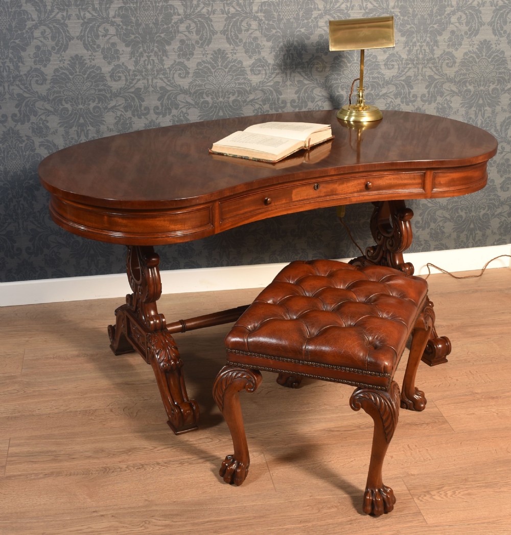 A Victorian mahogany kidney-shaped desk featuring carved trestle legs, a turned stretcher, and a single frieze drawer. View II
