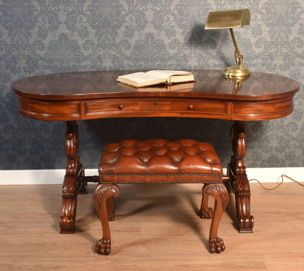 A Victorian mahogany kidney-shaped desk featuring carved trestle legs, a turned stretcher, and a single frieze drawer. View IV
