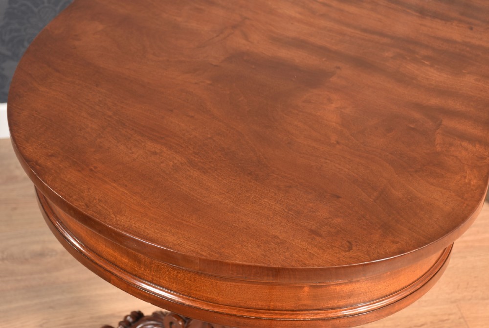 A Victorian mahogany kidney-shaped desk featuring carved trestle legs, a turned stretcher, and a single frieze drawer. View VI