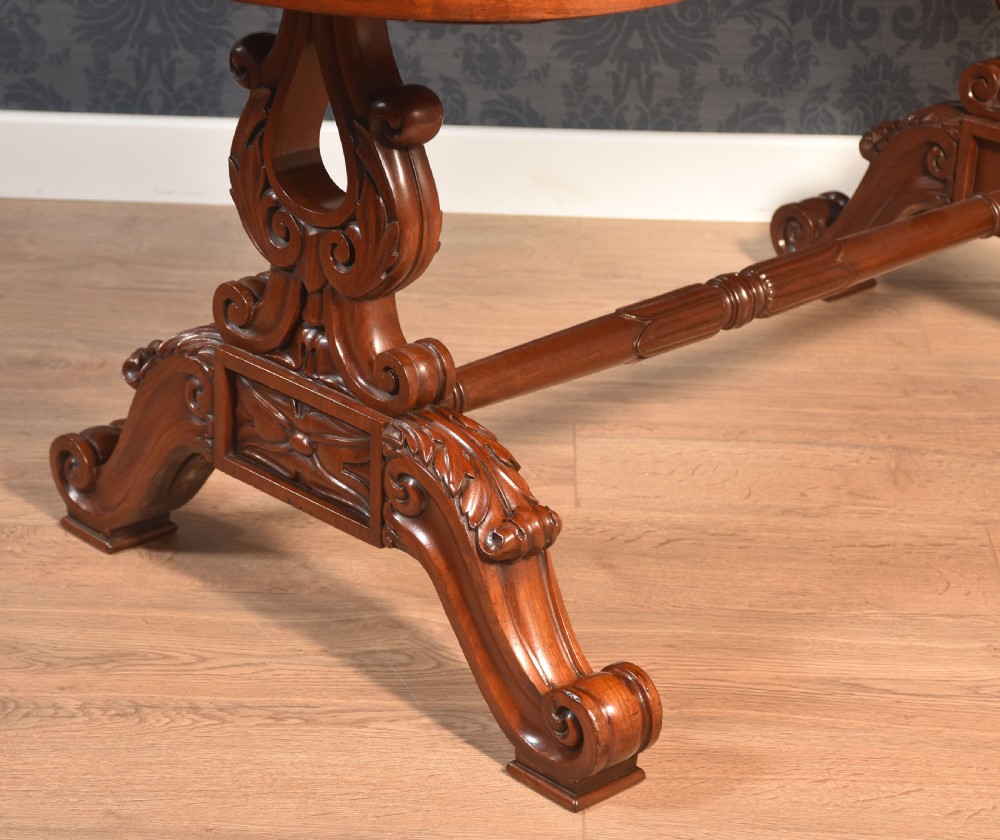 A Victorian mahogany kidney-shaped desk featuring carved trestle legs, a turned stretcher, and a single frieze drawer. View VIII