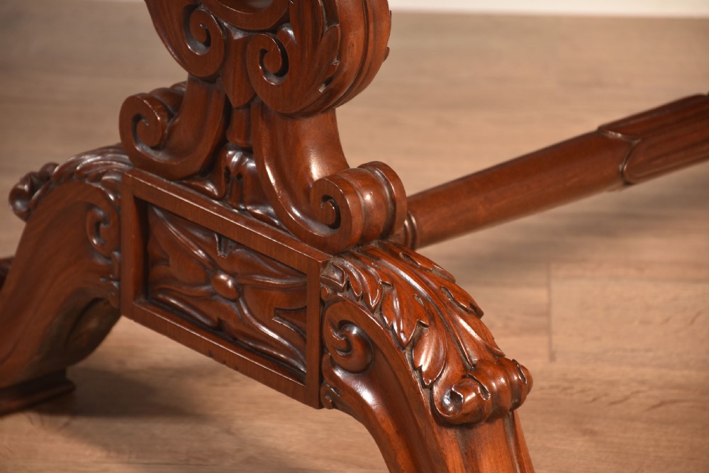 A Victorian mahogany kidney-shaped desk featuring carved trestle legs, a turned stretcher, and a single frieze drawer. View IX