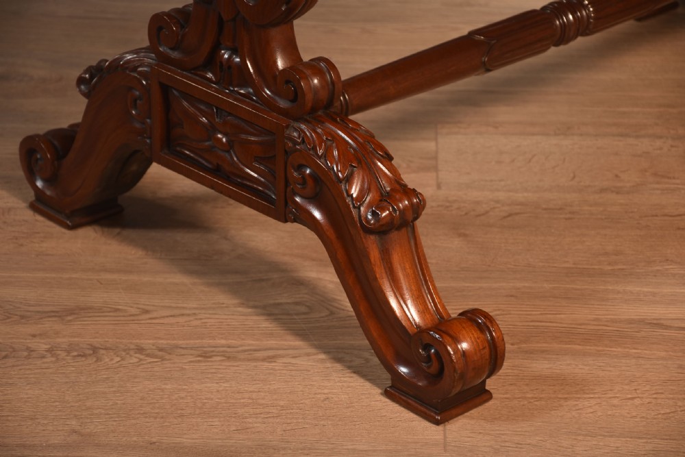 A Victorian mahogany kidney-shaped desk featuring carved trestle legs, a turned stretcher, and a single frieze drawer. View X