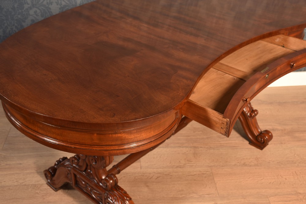 A Victorian mahogany kidney-shaped desk featuring carved trestle legs, a turned stretcher, and a single frieze drawer. View XII
