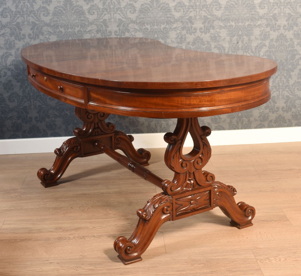 A Victorian mahogany kidney-shaped desk featuring carved trestle legs, a turned stretcher, and a single frieze drawer. View XIV