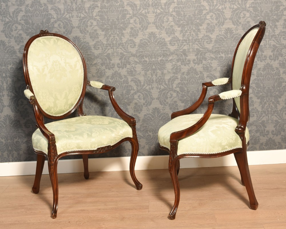 A pair of antique mahogany open armchairs featuring oval backrests, cabriole legs, and pale sage green damask upholstery. View IV